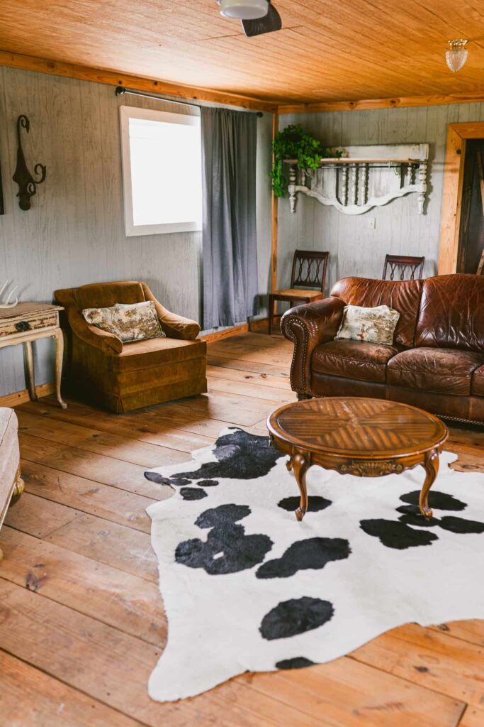 lounging area with leather couch and cowhide rug